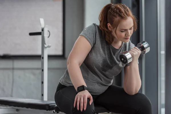 Curvy girl entraînement avec haltère dans la salle de gym — Photo de stock