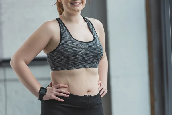 Primo piano vista di sorridente ragazza in sovrappeso in palestra — Foto stock