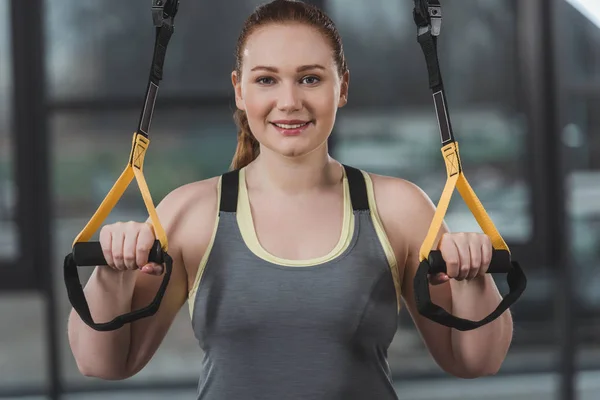 Niña obesa entrenando en elásticos en el gimnasio - foto de stock