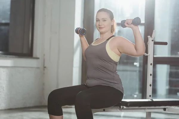 Curvy girl formazione con manubri in palestra — Foto stock