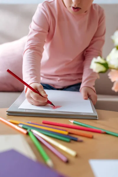 Vista de cerca del niño con síndrome de Down dibujo con lápices de colores - foto de stock