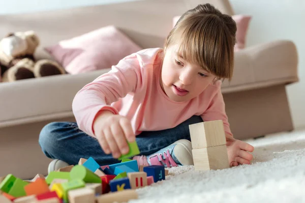 Kid with down syndrome playing with toy cubes — Stock Photo