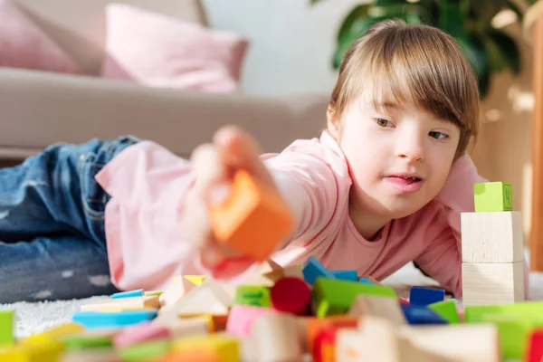 Niño con síndrome de Down edificio con cubos de juguete - foto de stock