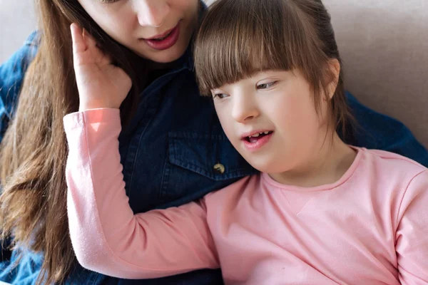 Мать нежно обнимает дочь с синдромом Дауна — стоковое фото