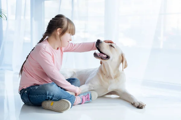 Menina com síndrome de down acariciando Labrador retriever cabeça — Fotografia de Stock