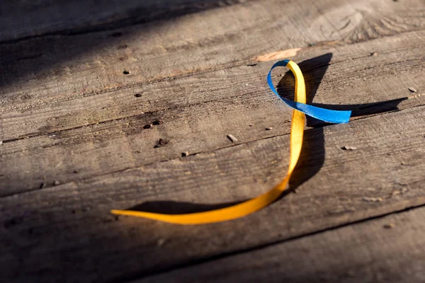 Blaues und gelbes Band auf hölzernem Hintergrund für Down-Syndrom-Tag Hintergrund — Stockfoto