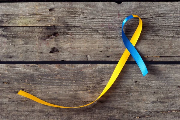 Down Syndrome Day blue and yellow ribbon on wooden background — Stock Photo