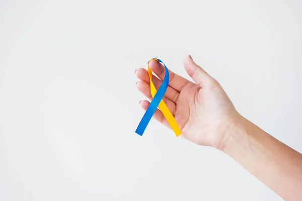 Female hand with Down Syndrome Day ribbon isolated on white — Stock Photo