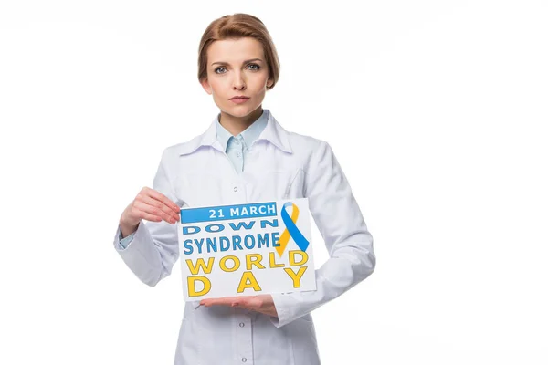 Young doctor holding paper with Down Syndrome World Day inscription isolated on white — Stock Photo