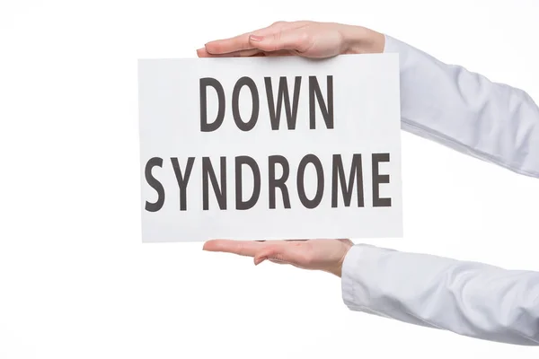 Weibliche Hände halten Schild mit Down-Syndrom-Text isoliert auf weiß — Stockfoto