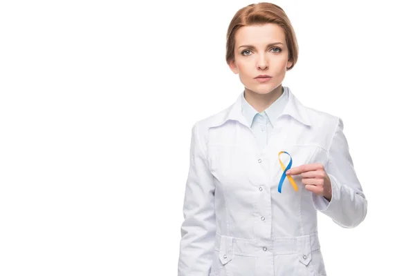 Doctor holding blue and yellow ribbon for Down Syndrome campaign isolated on white — Stock Photo