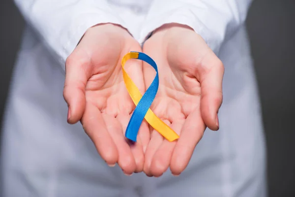 Vue rapprochée des mains de médecins féminines tenant le ruban de la Journée du syndrome de Down — Photo de stock