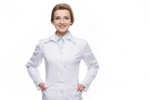Junge lächelnde Ärztin steht isoliert auf weißem Grund — Stockfoto