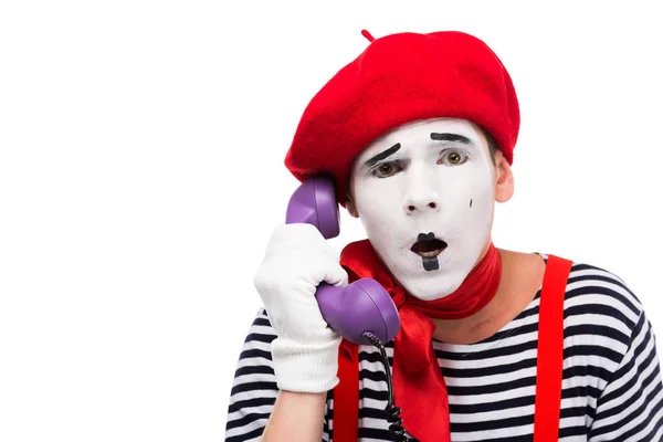 Shocked mime talking by ultra violet retro stationary telephone isolated on white — Stock Photo