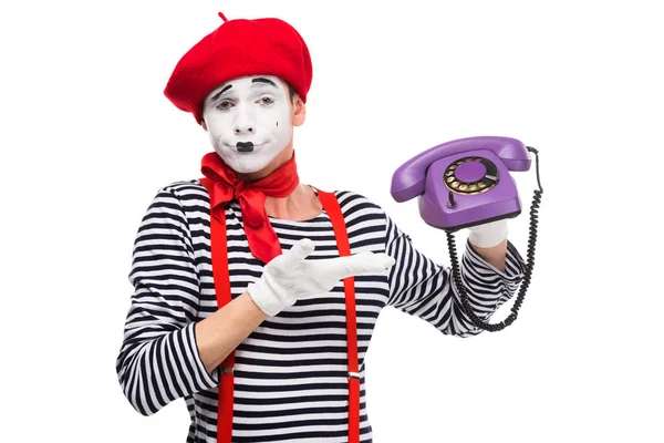 Mimo escéptico mostrando en ultra violeta teléfono fijo retro aislado en blanco - foto de stock