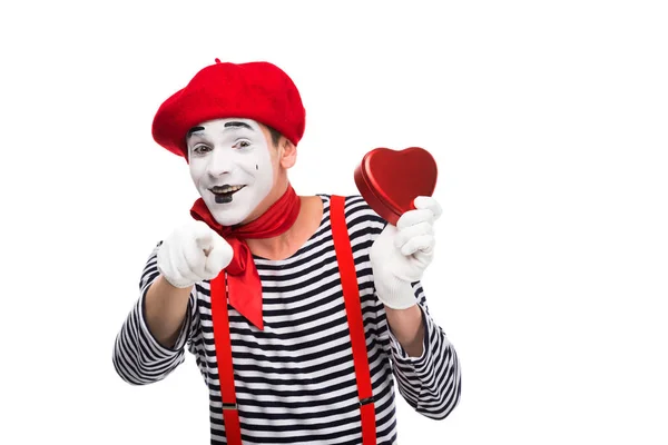 Mime holding heart shaped gift box and pointing on camera isolated on white, st valentines day concept — Stock Photo