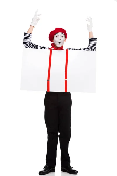 Grimacing mime holding empty board under suspenders with hands up isolated on white — Stock Photo