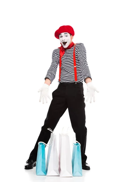 Happy mime showing shopping bags isolated on white — Stock Photo
