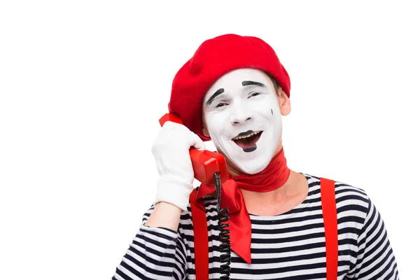 Lächelnder Pantomime, der mit festem Telefon auf weißem Grund spricht — Stockfoto