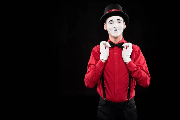 Happy mime fixing bow tie isolated on black — Stock Photo