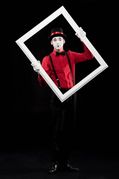 Mime holding frame and looking at camera isolated on black — Stock Photo