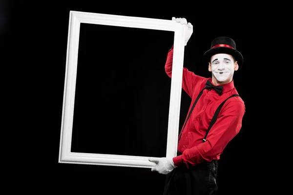 Smiling mime holding frame isolated on black — Stock Photo