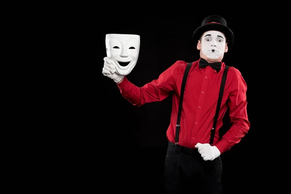 Peur mime tenant masque blanc isolé sur noir — Photo de stock