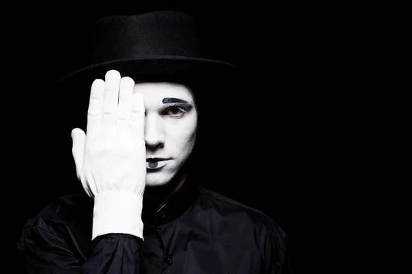 Mime covering eye and looking at camera isolated on black — Stock Photo