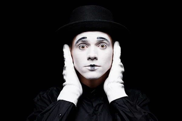 Mime covering ears and looking at camera isolated on black — Stock Photo
