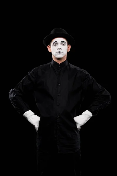 Mime standing with hands akimbo and looking at camera isolated on black — Stock Photo