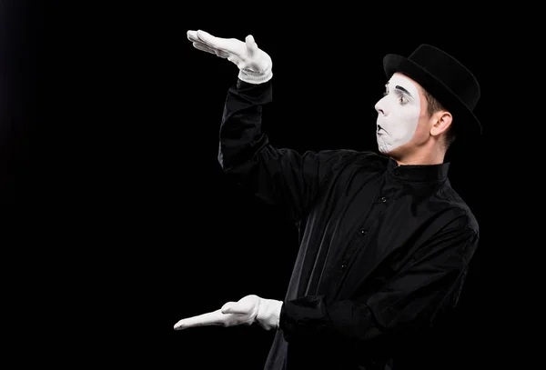 Surprised mime showing size of something isolated on black — Stock Photo