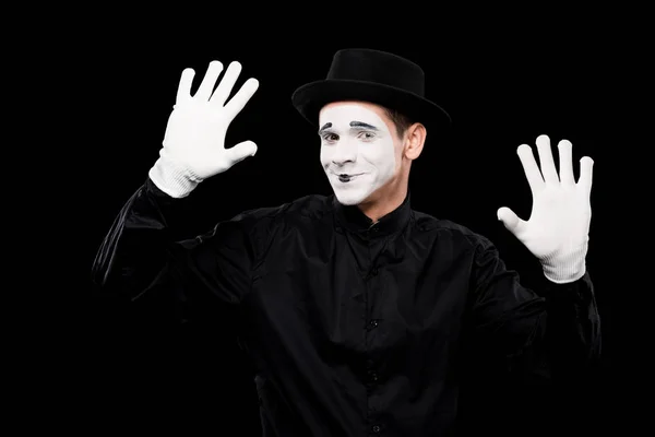 Smiling mime performing and touching something isolated on black — Stock Photo