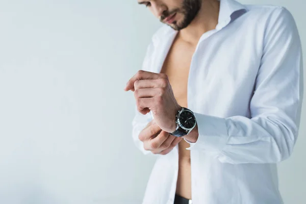 Bellissimo uomo in camicia bianca con orologio da polso, isolato su grigio — Foto stock