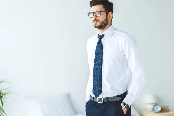 Schöner Geschäftsmann in weißem Hemd und Krawatte im Schlafzimmer stehend — Stockfoto