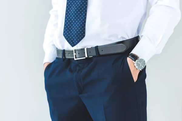 Cropped view of businessman with hands in pockets, isolated on grey — Stock Photo