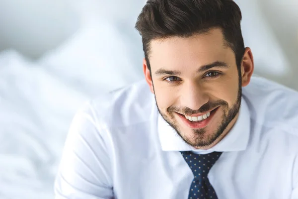 Портрет красивого бизнесмена в белой рубашке и галстуке, улыбающегося в камеру — стоковое фото