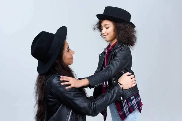 Mother and daughter in similar clothes looking at each other isolated on grey — Stock Photo