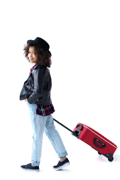 Vue latérale de élégant petit enfant marchant avec des bagages isolés sur blanc — Photo de stock