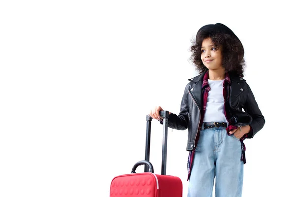 Adorable niño pequeño en ropa elegante con maleta aislada en blanco - foto de stock