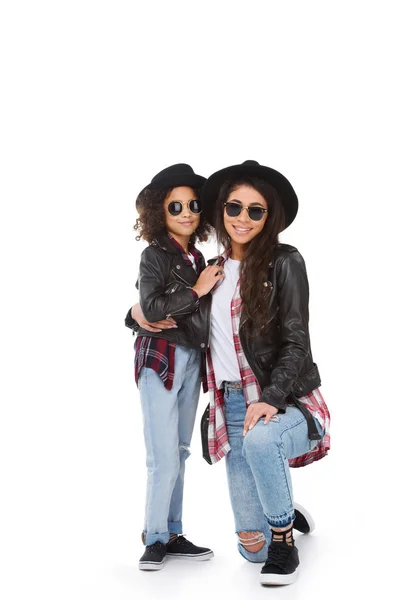 Stylish mother and daughter in hats and sunglasses looking at camera isolated on white — Stock Photo
