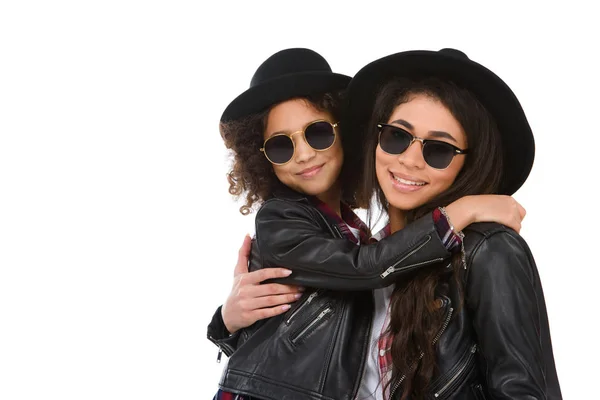 Close-up portrait of happy embracing mother and daughter in sunglasses looking at camera isolated on white — Stock Photo