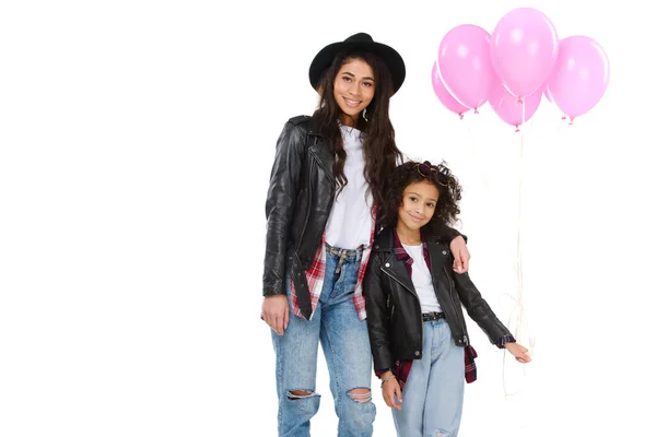 Hermosa madre e hija en ropa similar con globos rosados aislados en blanco - foto de stock