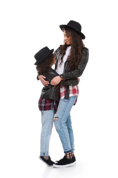 Stilvolle glückliche Mutter und Tochter in Lederjacken umarmen und schauen in die Kamera isoliert auf weiß — Stockfoto