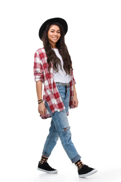 Beautiful walking young woman in stylish plaid shirt isolated on white — Stock Photo