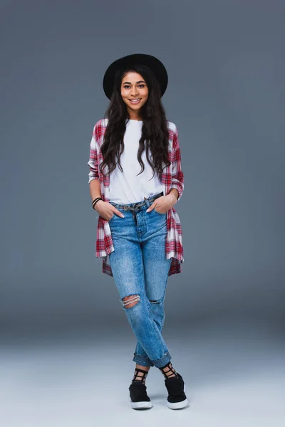 Beautiful young woman in stylish clothing and hat on grey — Stock Photo