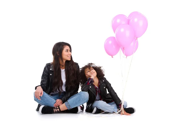 Мати і дочка в шкіряних куртках з купою рожевих кульок ізольовані на білому — стокове фото