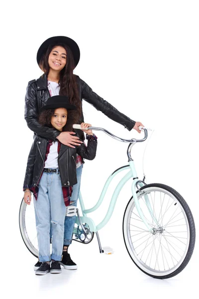 Elegante joven madre e hija con bicicleta aislada en blanco - foto de stock