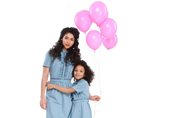 Abraçando mãe e filha com bando de balões rosa isolados em branco — Fotografia de Stock