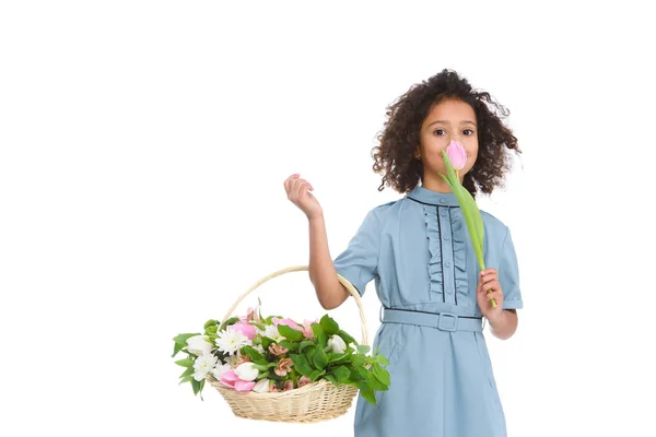 Schöne kleine Kind hält Korb mit Blumen isoliert auf weiß — Stockfoto