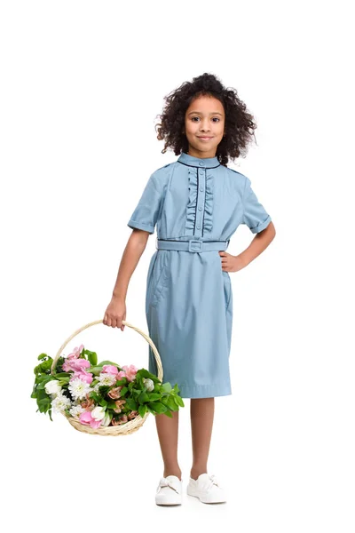 Entzückendes kleines Kind mit einem Korb voller Blumen auf weißem Grund — Stockfoto